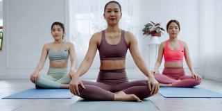 亚洲女瑜伽老师在课堂上教授学生基本练习、运动理念和健康