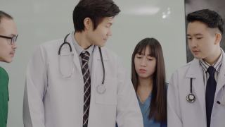 一群亚洲医生在医院会议室开会讨论治疗方针。视频素材模板下载