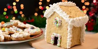用白奶油装饰圣诞姜饼屋。圣诞糖果和甜点