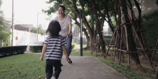 慢镜头:快乐的孩子和妈妈在公园里玩耍。