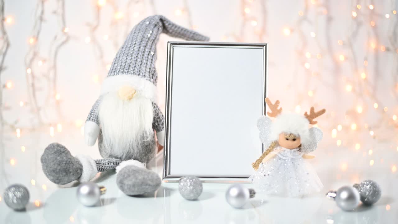 可爱的银制圣诞摆设，小矮人、天使和小饰品围绕在银空框的桌子上。