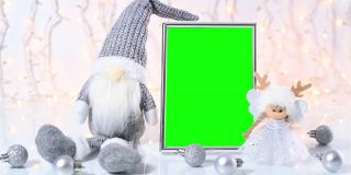 绿色屏风圣诞框四周环绕着圣诞小精灵、天使和桌上的小银饰