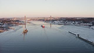 无人机在瑞典哥德堡一座美丽的大桥附近的一艘红色渔船上空拍摄。视频素材模板下载