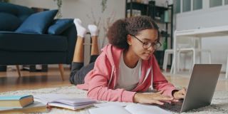 戴着眼镜的好奇少女在笔记本电脑上做练习，上在线课程