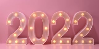 2022年新年创意设计概念编号来自粉色背景的黄色灯泡