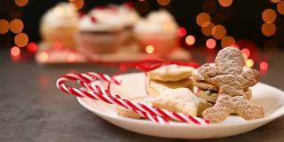 桌上放着传统的美味的圣诞自制糖果。供应不同形状的圣诞姜饼饼干和奶油杯状蛋糕