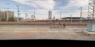 从火车上望向窗外，火车慢慢地离开了中国河南省郑州东站