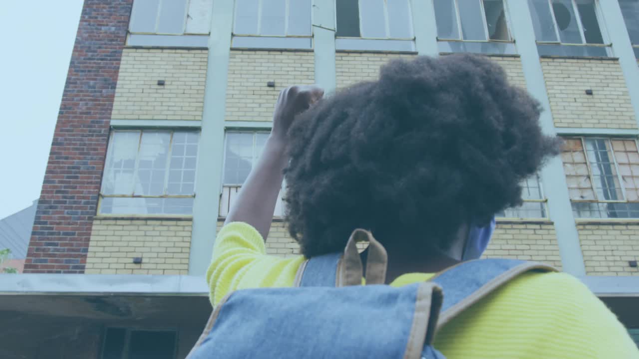 非裔美国妇女在城市街道举起拳头的社交媒体通知动画