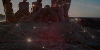 在阳光灿烂的沙滩上，活跃的交流网络覆盖着女性朋友的笑声