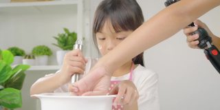 亚洲女孩拍摄视频，她的姐姐在家自制饼干，为病毒视频或TikTok在家，新一代的时尚生活理念。