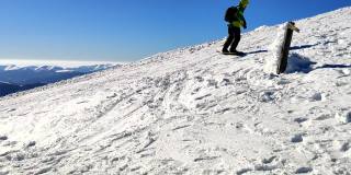在阳光明媚的日子里，男子在雪山上滑雪