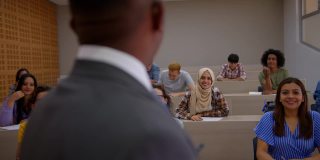 一名穆斯林大学生在课堂上举手向老师提问，大家都很开心地听着