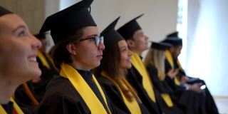骄傲的大学生们在毕业典礼上兴奋地聆听着主讲人