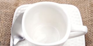 天然有机健康饮品配料从茶匙中倒入白色茶杯中