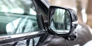 侧视摄像头安装在一辆黑色轿车的侧视镜上。360度全方位摄像头。新技术。现代汽车技术。