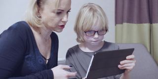 母亲和她的儿子在数码平板电脑上玩慢动作素材视频