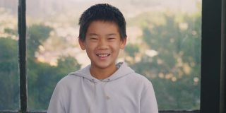 快乐和自信的混血亚洲男孩微笑，十几岁的肖像