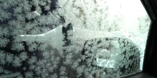 年轻女子用雪刷刮冰从车窗
