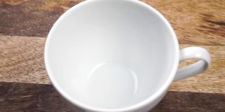 木桌上的白色杯子里放着一茶匙的干果花茶