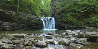 令人惊叹的风景，美丽的山河瀑布与白色泡沫水从岩石悬崖下降在夏季雨林