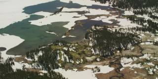 在黄石国家公园里，一条小溪蜿蜒地流进了山间的湖泊，春雪还在那里徘徊