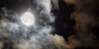 月亮和云景观，移动密度更大的云在月亮之前