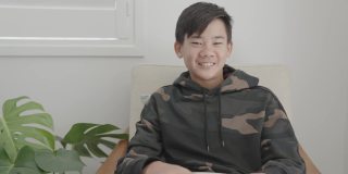 亚洲十多岁男孩的肖像POV在家里视频通话，使用摄像头放大在线虚拟课堂，社交距离，家庭教育，远程学习，新常态的概念