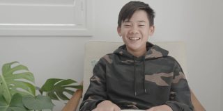 亚洲十多岁男孩的肖像POV在家里视频通话，使用摄像头放大在线虚拟课堂，社交距离，家庭教育，远程学习，新常态的概念