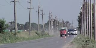 阿根廷圣达菲省农村道路上的汽车和卡车。