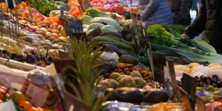 买家购买产品。一个大城市的蔬菜市场。种类繁多的蔬菜和水果可供选择。健康的新鲜有机素食食品在柜台上。德国的价格标签。