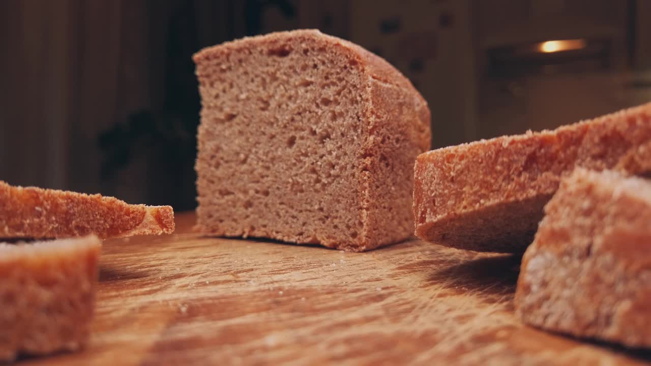 农场面包躺在厨房的一块木板上。早餐切成的酸面包片。移动滑块极端接近股票镜头