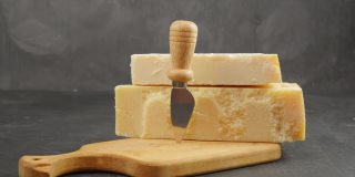 帕尔玛。两种帕尔马干酪。帕尔玛刀。帕尔马奶酪放在木板上。24个月和48个月