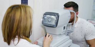 眼科医生在眼科诊所工作。女专家使用眼睛生物显微镜检查成年男子的视力。