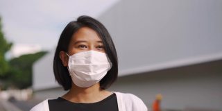 亚洲妇女戴着防护口罩走路