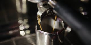 将美式咖啡或浓咖啡从专业的咖啡机倒进咖啡杯。早上烤黑咖啡
