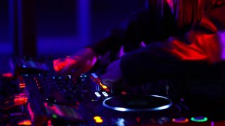 Techno音乐dj女孩在夜总会玩。职业女性音乐节目主持人设置在流行的夜总会狂欢派对视频素材模板下载