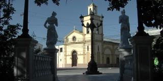 阿根廷一个小村庄广场上的老教堂和妇女雕像。