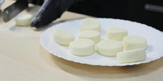 糕点师用抹刀制作圆形凝乳，然后把它们放在盘子里。