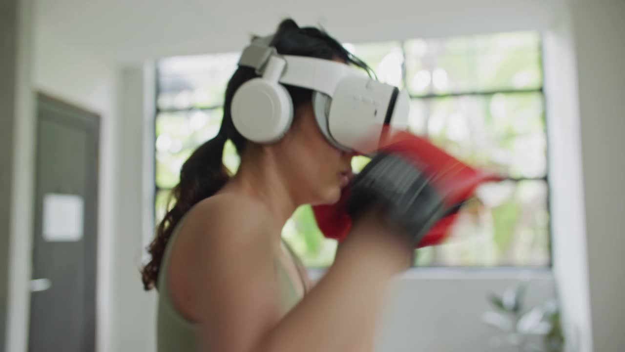 体育女子拳击在虚拟现实头盔训练踢在家里虚拟现实