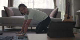 女性在家锻炼和练习用平板电脑燃烧脂肪
