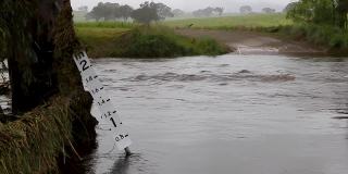 洪水深度指示器显示洪水穿过乡村道路的深度