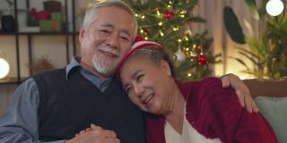 老长辈老长辈亚洲退休夫妇在沙发上一起享受着快乐的谈笑和快乐的在家，亚洲老长辈成熟的成年人呆在家里隔离圣诞节日的背景