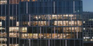 在现代摩天大楼的办公室里，人们工作到很晚。