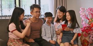 春节期间，一个亚洲小孩在客厅里接受父母的春节红包。