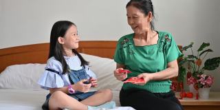 亚洲孙女春节期间在卧室里接受奶奶给的红包