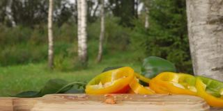 新鲜成熟的胡椒片以慢动作落在木板上