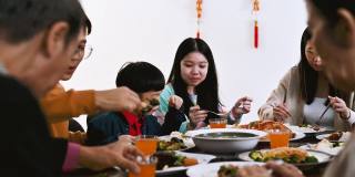 中国农历新年，欢乐的亚洲一家三口欢聚一堂，共进年夜饭