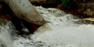 脏水和化学废料从管道中排入山里的河流。环境污染