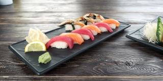 手握寿司和生鱼片，木桌。