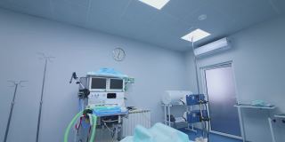 空荡荡的手术室里有现代化的医疗设备。无菌手术室可在医院进行手术。手术台上方有一盏明亮的灯。